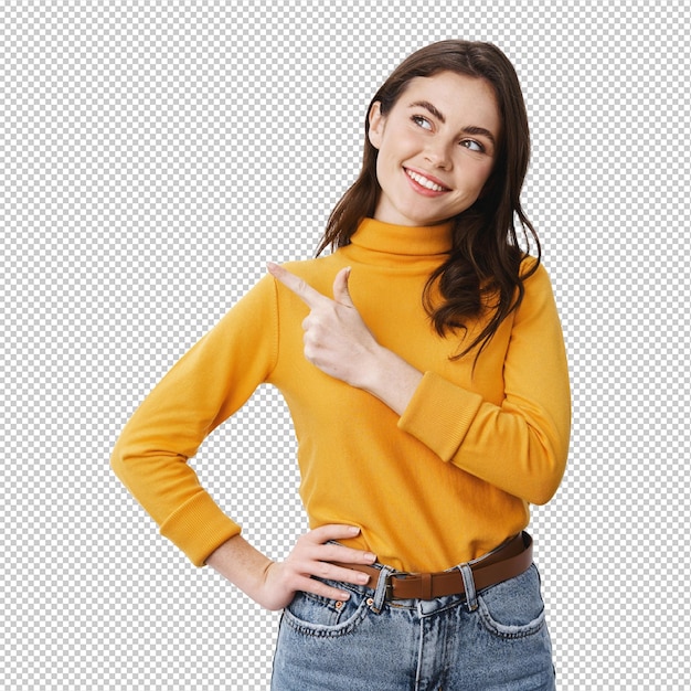 Una ragazza sorridente e sicura che guarda e indica a sinistra l'offerta promozionale che fissa con un viso soddisfatto e determinato la pubblicità che fa una scelta in piedi sul muro bianco