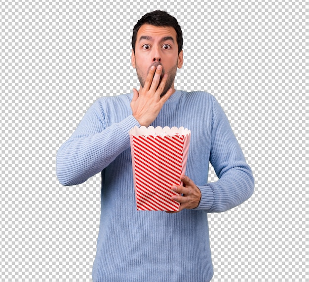 Uomo con maglione blu che mangia i popcorn