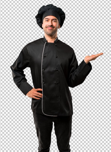 Uomo del cuoco unico in uniforme nera che tiene immaginario del copyspace sulla palma per inserire un annuncio