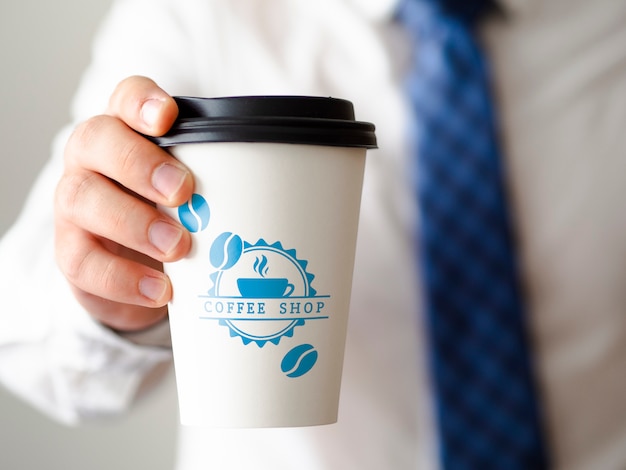 Uomo di vista frontale che tiene un modello della tazza di caffè