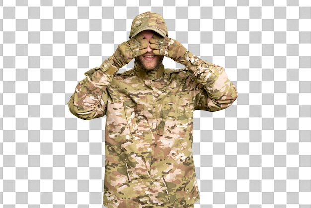 Uomo militare sopra lo sfondo isolato della chiave cromata che copre gli occhi con le mani