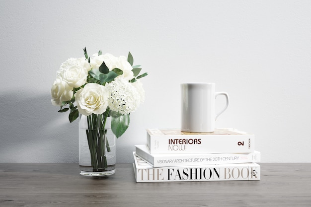 vase avec des fleurs, une tasse et des livres empilés