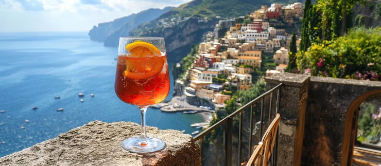 PSD un verre d'aperol spritz sur un balcon surplombant la côte amalfitaine en italie