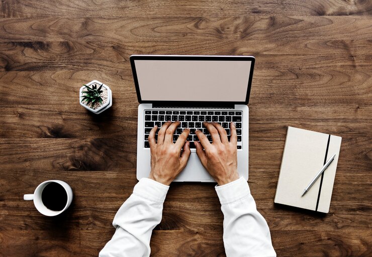 PSD vista aérea de um homem usando um computador portátil em uma mesa de madeira