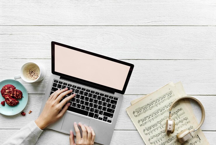 PSD vista aérea de una mujer usando una computadora portátil en un concepto de espacio de trabajo de música de mesa de madera