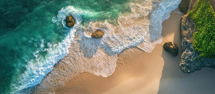 PSD vista aérea de las olas turquesas del océano chocando contra una playa de arena