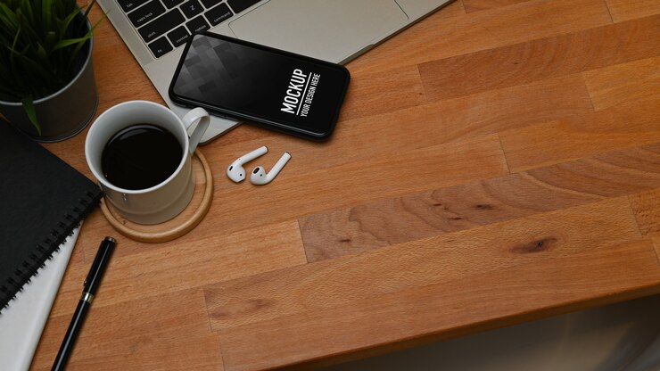 PSD vista dall'alto del tavolo in legno con mockup di smartphone