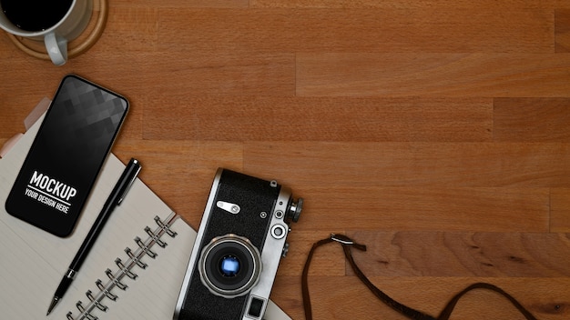 Vista dall'alto dell'area di lavoro con mockup di smartphone e forniture per ufficio