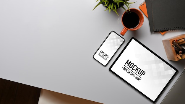 Vista dall'alto dell'area di lavoro con mockup di tablet e smartphone