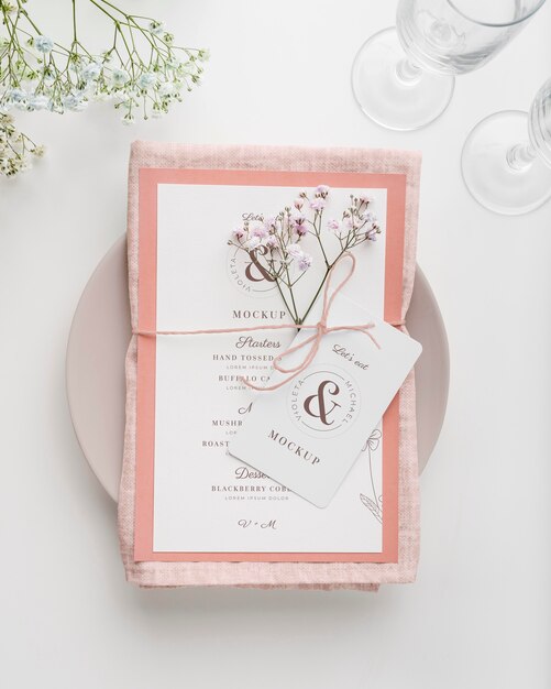 Vista dall'alto della disposizione dei tavoli con mock-up di menu primaverile e fiori
