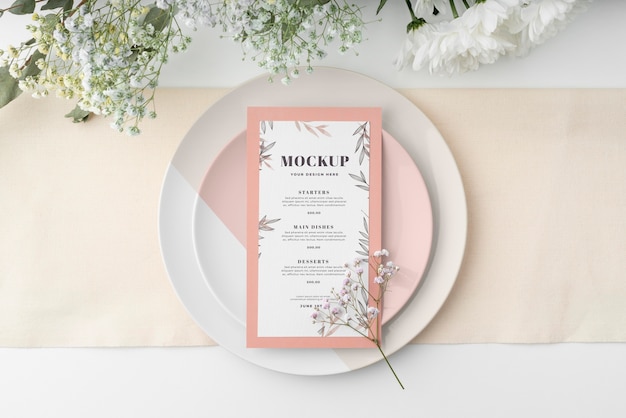 Vista dall'alto della disposizione dei tavoli con mock-up di menu primaverile e fiori
