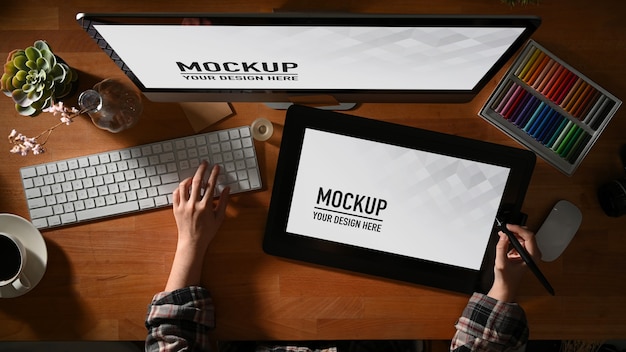 Vista dall'alto della donna graphic designer che lavora con tablet e computer mockup