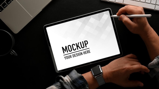 Vista dall'alto della mano maschio utilizzando il mockup di tavoletta digitale