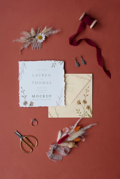 Vista dall'alto di mock-up invito a nozze di carta rustico con foglie e fiori