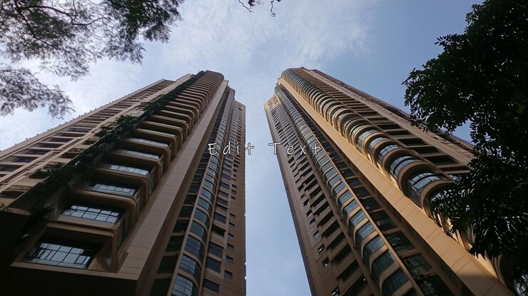 PSD vista de baixo ângulo de duas altas torres residenciais modernas contra um céu parcialmente nublado