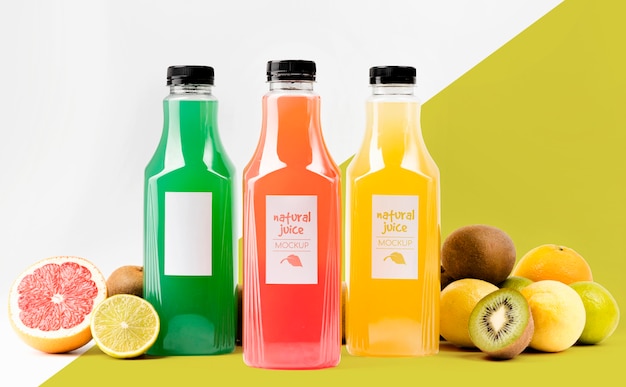 Vista frontal de botellas de jugo con pomelo y kiwi