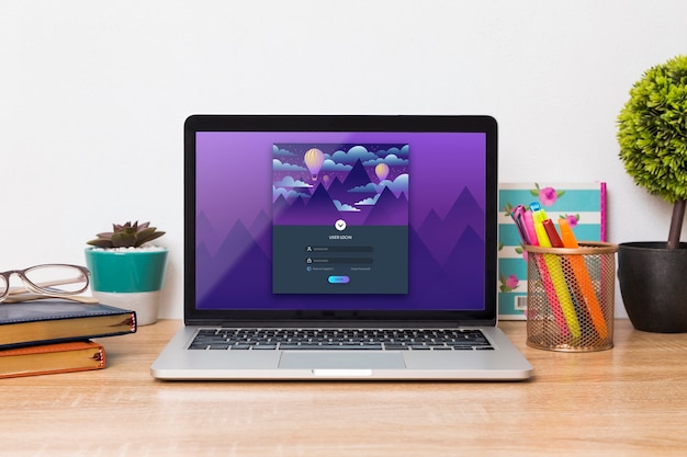 PSD vista frontal de la computadora portátil en el escritorio con bolígrafos y agendas