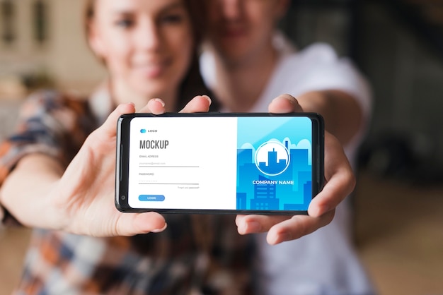 Vista frontal de casal segurando uma maquete de smartphone
