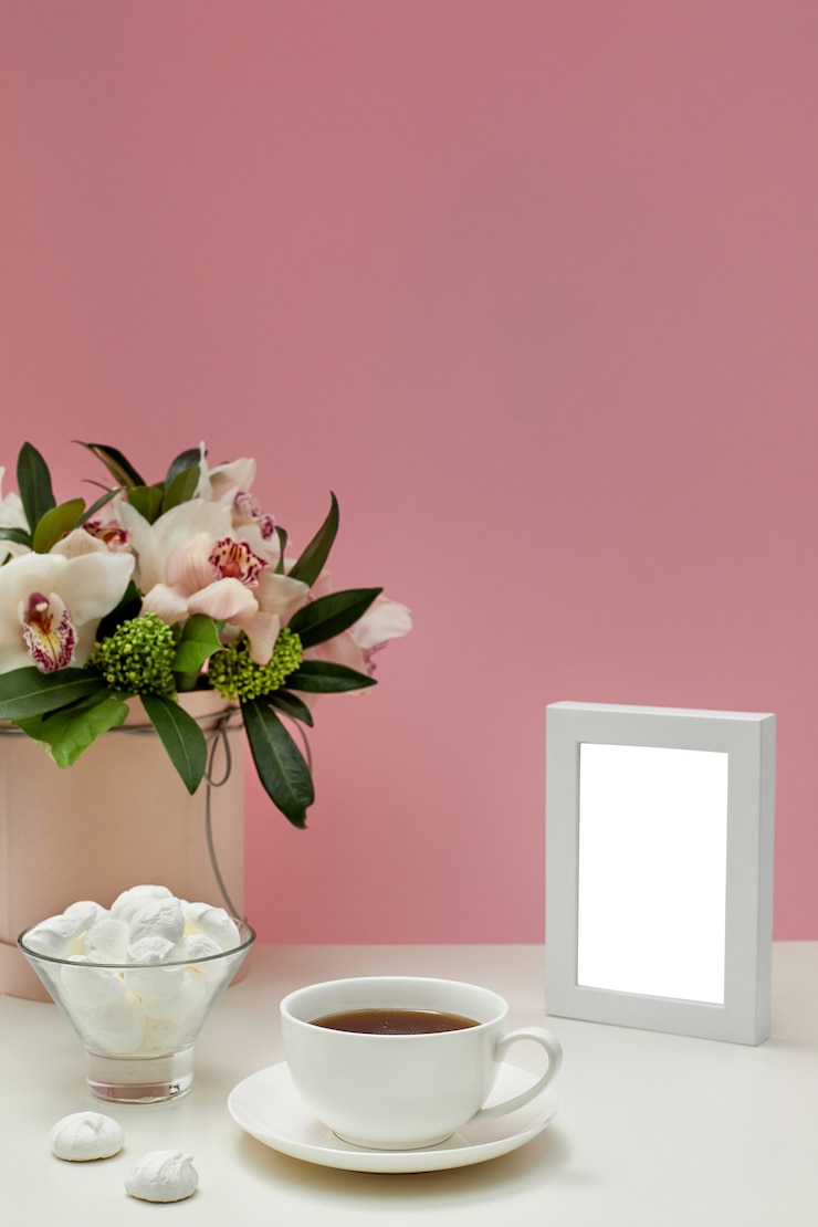 PSD vista frontal maqueta en blanco del marco de fotos. flores de orquídeas, una taza de té y dulces.