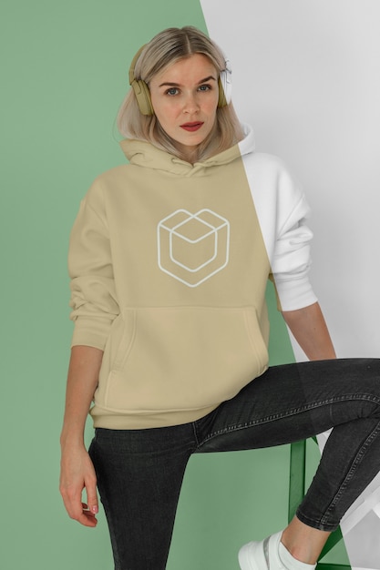 Vista frontal de la mujer elegante en sudadera con capucha con auriculares