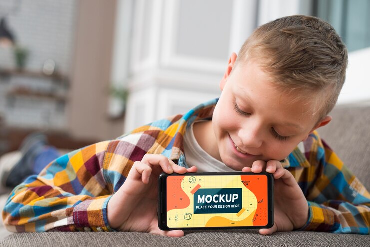 PSD vista frontal del niño sonriente en el sofá con smartphone