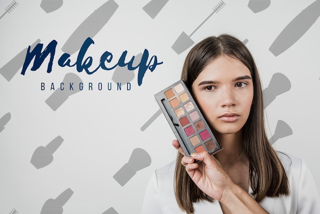 Vista frontale della ragazza con la tavolozza di trucco