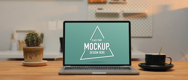 Vista ingrandita del piano di lavoro con laptop mockup, tazza di caffè e vaso di cactus