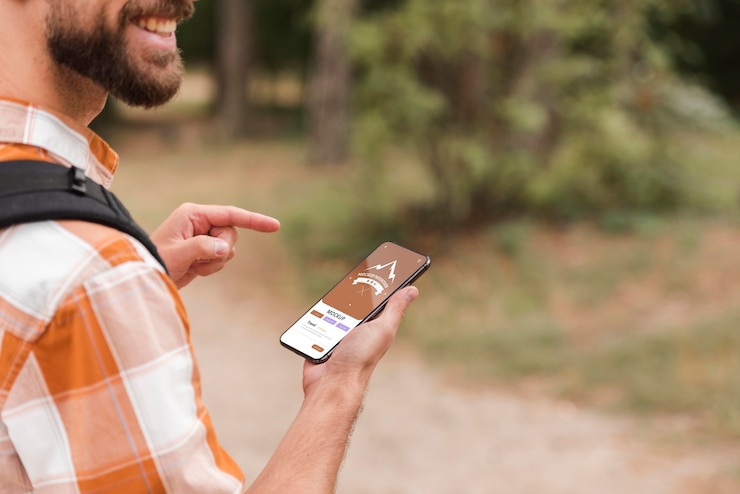 PSD vista laterale dell'uomo sorridente che tiene smartphone durante il campeggio