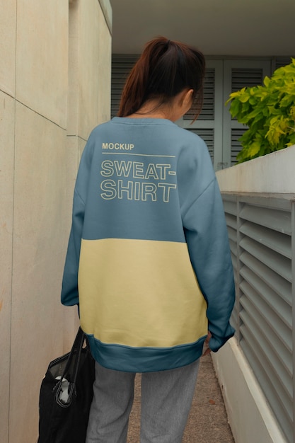Vista posteriore donna che posa con un maglione