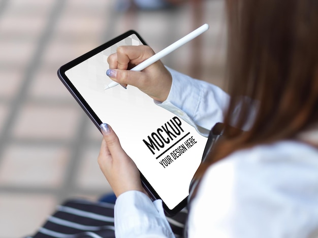 Vista ravvicinata della donna utilizzando il mockup di tavoletta digitale