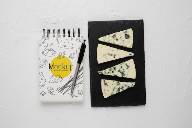 Vista superior del cuaderno y bolígrafo con queso mohoso