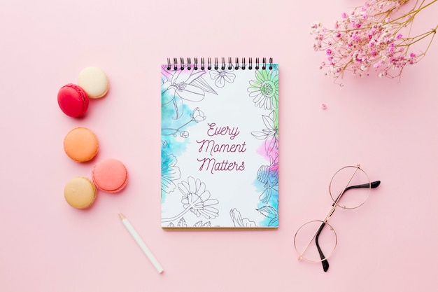 Vista superior do notebook com flores e macarons