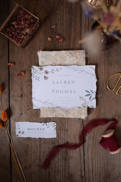 Vista superior de la invitación de boda rústica de maqueta de papel con hojas y flores