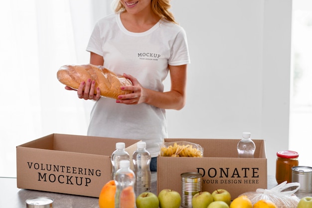 PSD voluntaria sonriente preparando comida en caja para donación