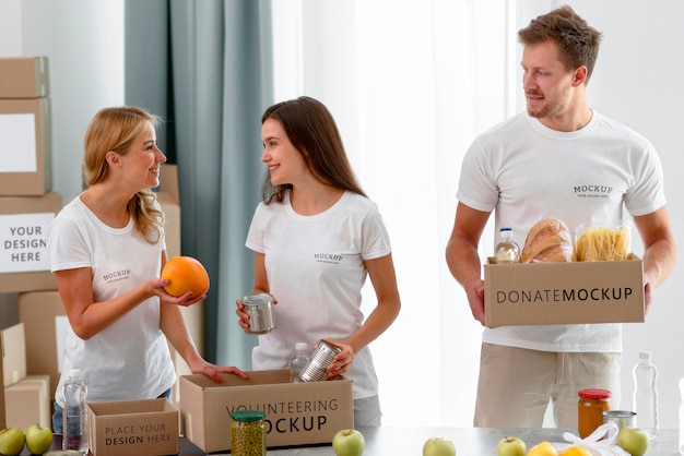 Voluntarios felices preparando cajas de provisiones para donación