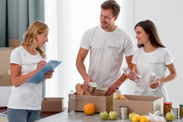 Voluntarios sonrientes preparando cajas de provisiones para donaciones