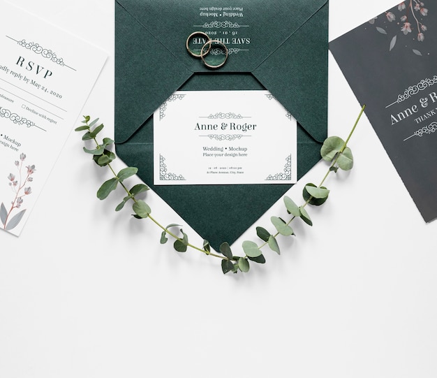 Vue de dessus des cartes de mariage avec anneaux et plantes