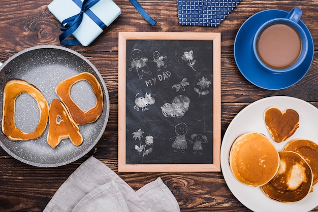 PSD vue de dessus du tableau noir avec crêpes et café pour la fête des pères