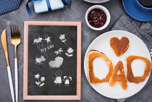 PSD vue de dessus du tableau noir pour la fête des pères avec crêpes et muffins