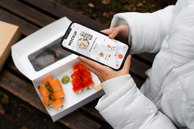 PSD vue de dessus femme avec smartphone et sushi