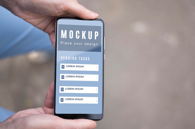 Vue de dessus des mains tenant le smartphone d'affaires