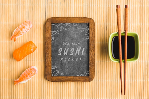 Vue de dessus des sushis avec des baguettes et tableau noir