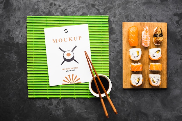 Vue de dessus des sushis sur planche à découper avec des baguettes et de la sauce soja