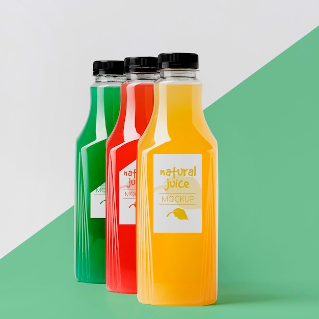 Vue de devant d'un assortiment de bouteilles de jus transparentes avec bouchons