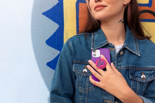 Vue de face femme utilisant popsocket sur son téléphone