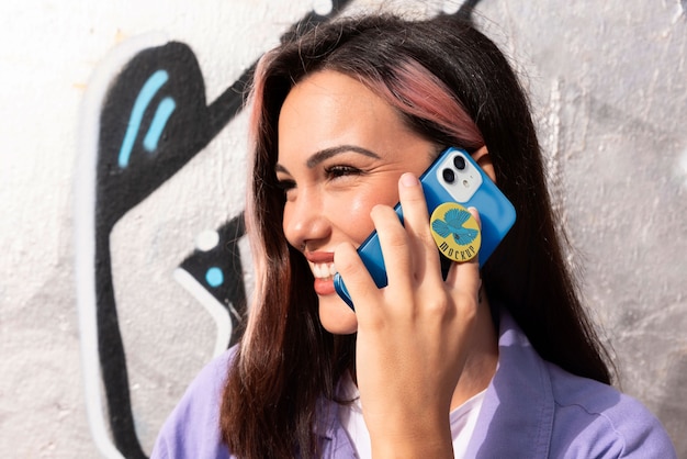 Vue latérale femme utilisant popsocket sur son téléphone