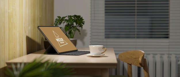 Vue latérale de l'intérieur confortable du bureau à domicile dans la tablette numérique du salon avec clavier sur table en bois