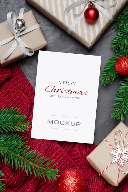 Weihnachts- oder neujahrsgrußkartenmodell mit dekorierten geschenkboxen und tannenzweigen