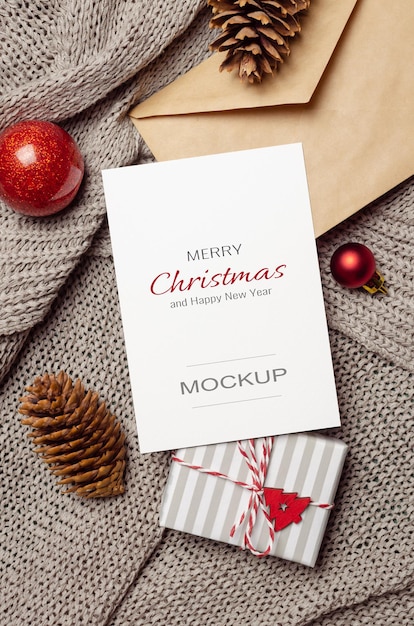 Weihnachts- oder Neujahrsgrußkartenmodell mit Geschenkbox, Zapfen, Umschlag und festlicher Dekoration
