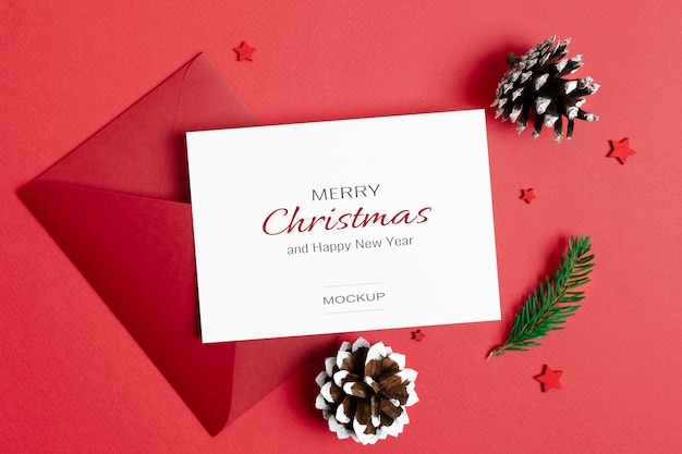 Weihnachtsgruß- oder einladungskartenmodell mit umschlag- und kegeldekorationen auf rot